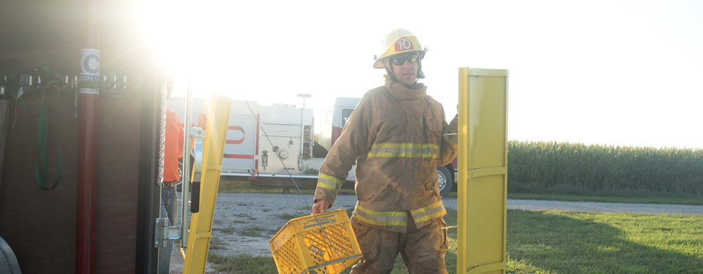 Member of the Gowrie, Iowa, Fire Department put on protection gear and assemble a rescue tube as part of a mock grain bin rescue.